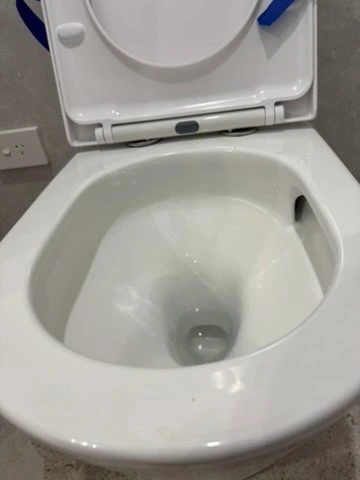 Close view of the angled toilet bowl jets that create a tornado flush