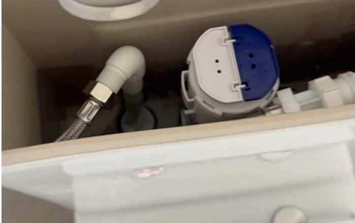 Open universal toilet cistern plumbed as bottom entry with the flexible hose running to the pan base