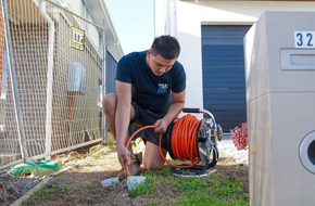 TM Pro plumber using a drain machine to clear a blocked drain outside a home