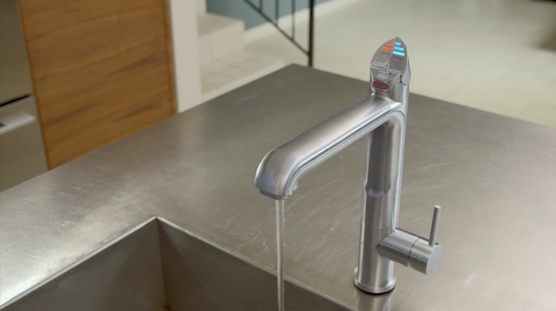 Filtered water tap running into a stainless steel kitchen sink