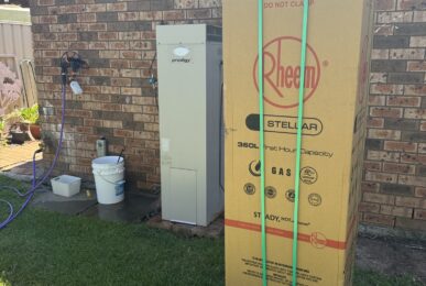 Old Dux hot water heater next to new Rheem Stellar gas storage hot water heater upgrade in St Helens Park