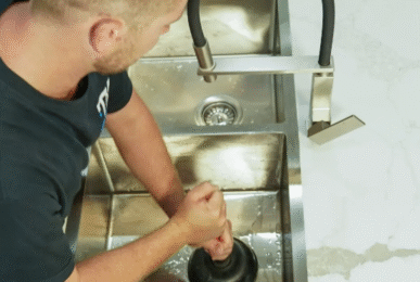 TM Pro Plumbing clearing a blocked kitchen sink in a Wolli Creek house.