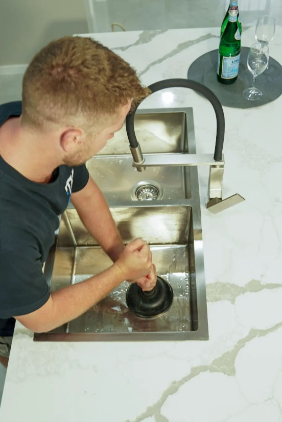 TM Pro Plumbing clearing a blocked kitchen sink in a Wolli Creek house.