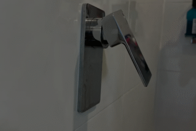A plumber replacing a Phoenix mixer cartridge in a Wolli Creek apartment shower.