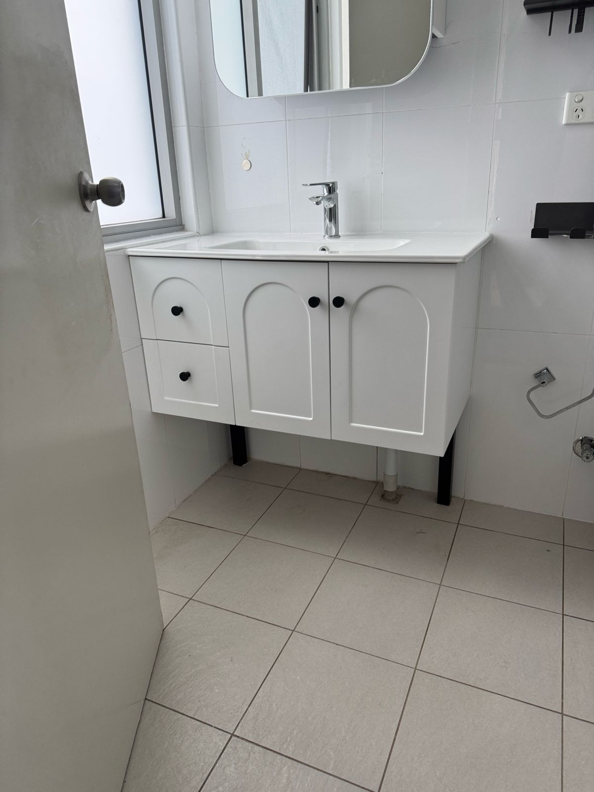 Newly installed white bathroom vanity and mirrored shaving cabinet in a Wolli Creek unit by TM Pro Plumbing.